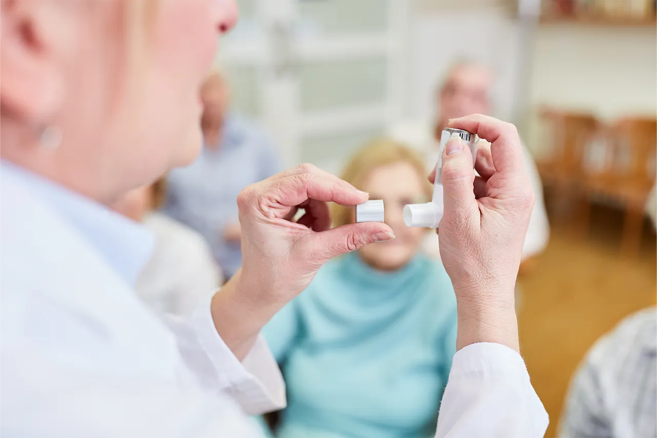 A woman showing how to use an asthma puffer