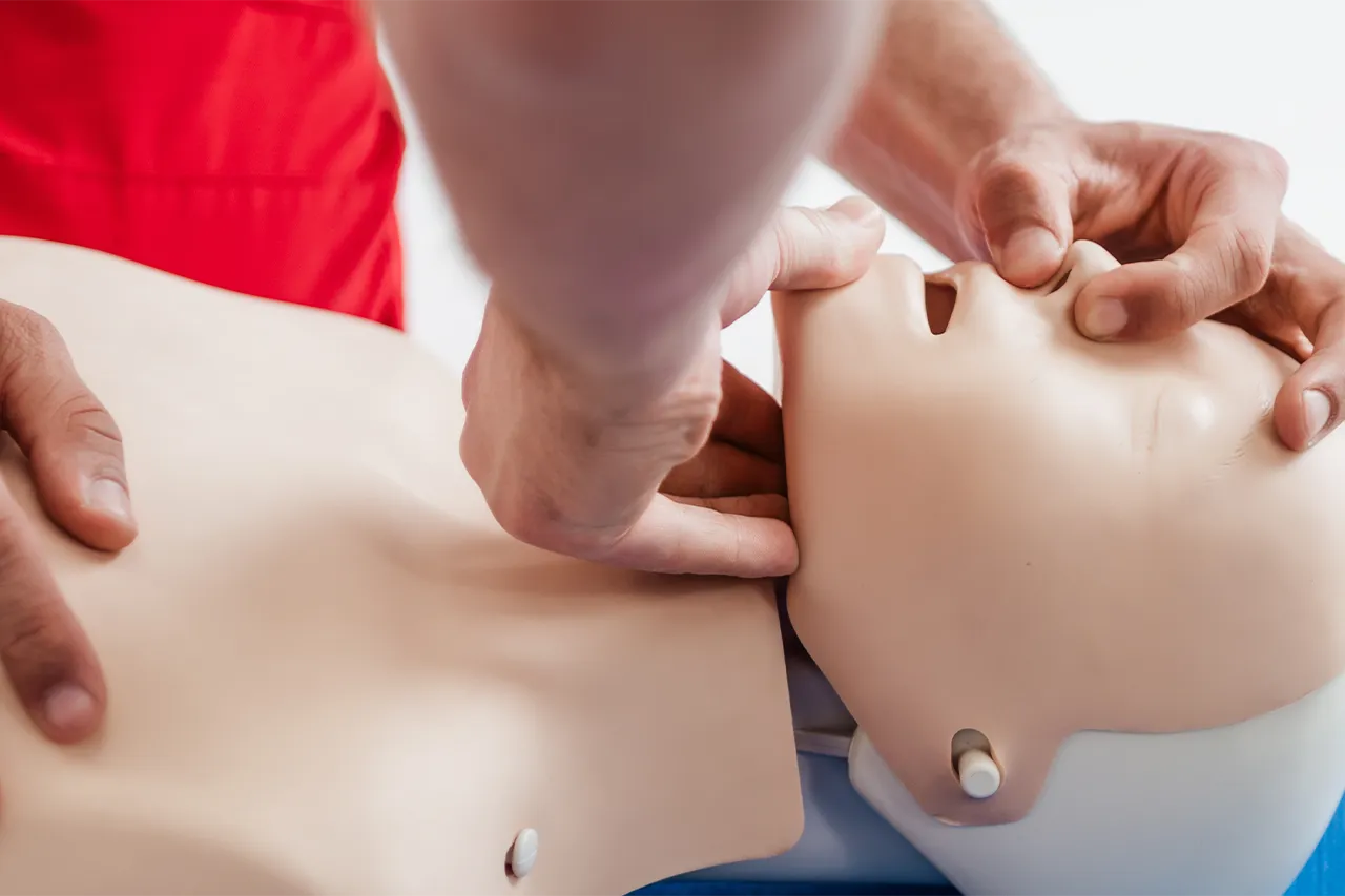 A man performing CPR on a dummy