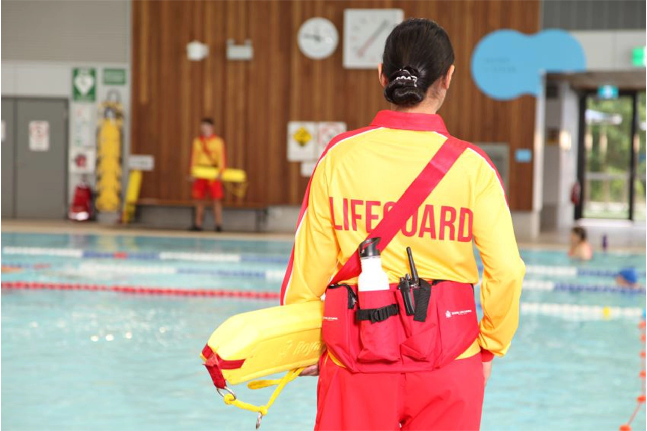 A female lifeguard supervising an indoor pool